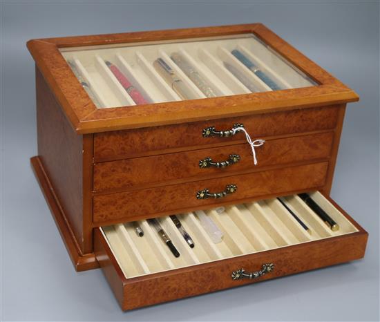 A burr wood four-drawer pen collectors cabinet containing various pens, cabinet 28 x 21 x 15cm